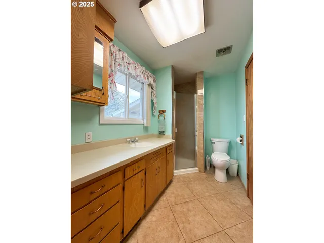 a spacious bathroom with a double vanity sink toilet and a mirror