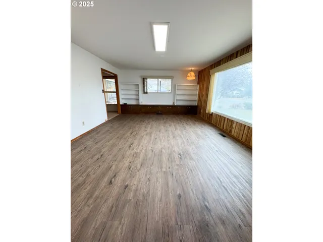 a view of a room with wooden floor and windows