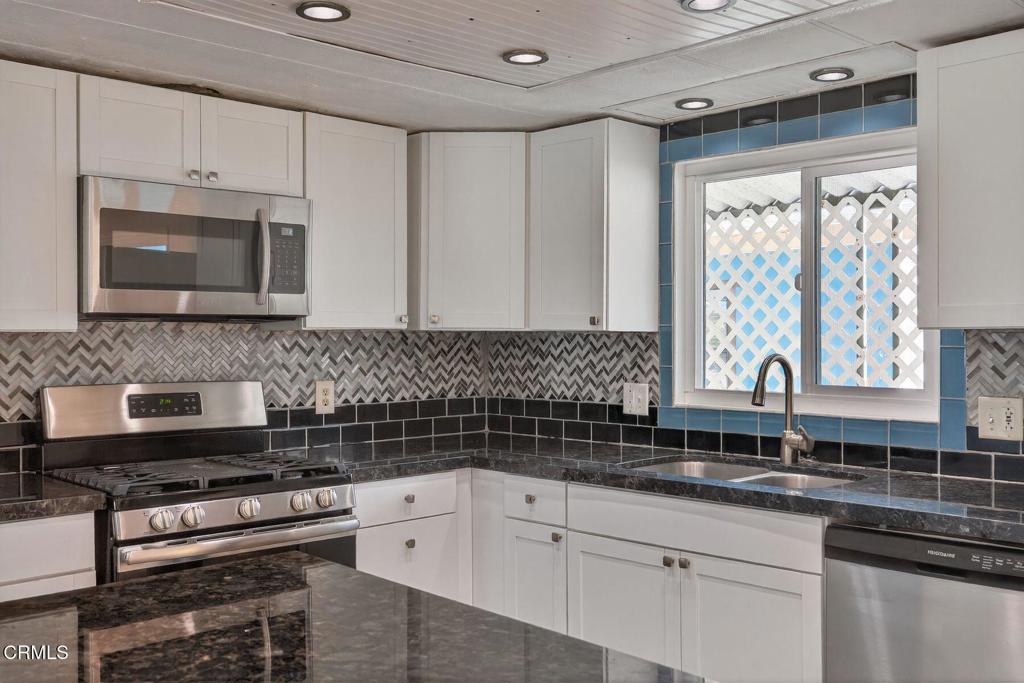 5540 West 5th Street, Unit 111 Oxnard, CA 93035 - Photo 13 of 35 a kitchen with stainless steel appliances a stove sink and microwave