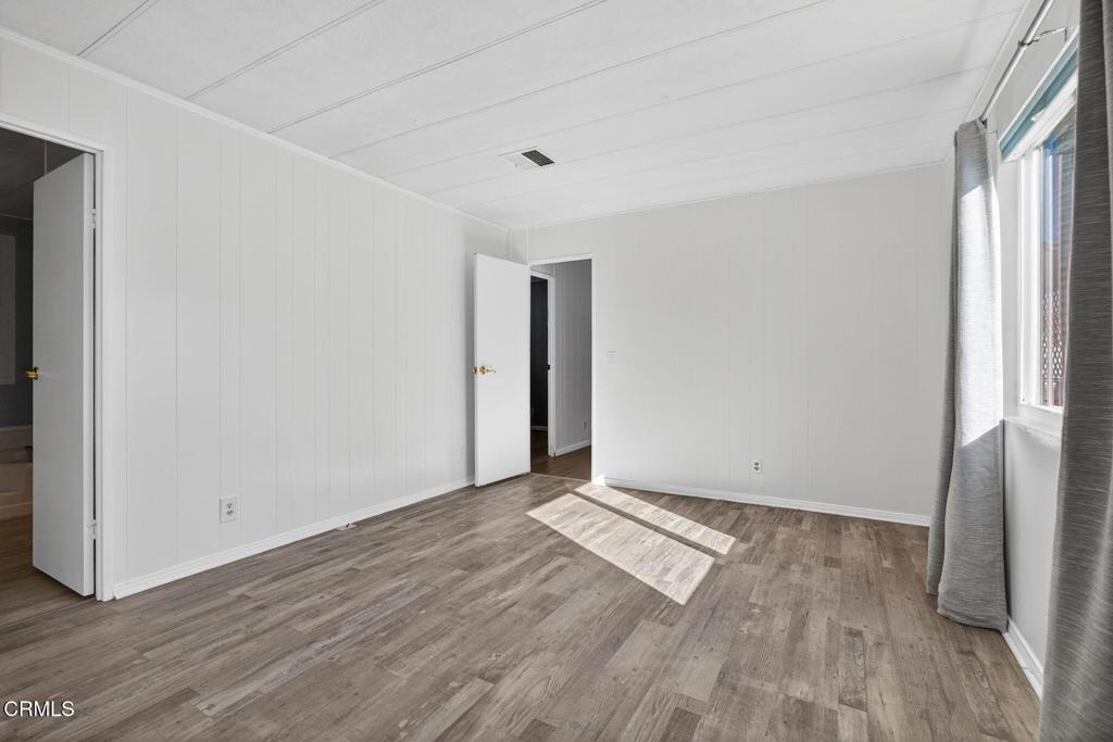 5540 West 5th Street, Unit 111 Oxnard, CA 93035 - Photo 17 of 35 an empty room with wooden floor and a window