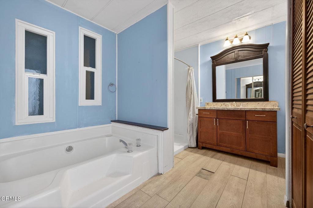 5540 West 5th Street, Unit 111 Oxnard, CA 93035 - Photo 18 of 35 a bathroom with a tub sink and mirror