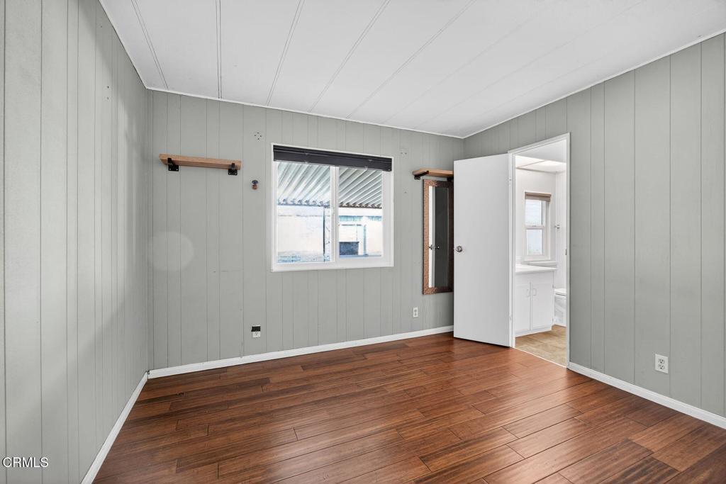5540 West 5th Street, Unit 111 Oxnard, CA 93035 - Photo 22 of 35 a view of an empty room with wooden floor and a window