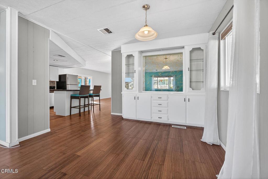 5540 West 5th Street, Unit 111 Oxnard, CA 93035 - Photo 7 of 35 a view of a livingroom with furniture wooden floor and front door