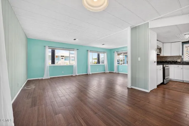 a kitchen with a dining table chairs and refrigerator