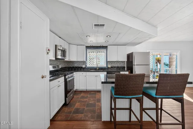 a kitchen with granite countertop a sink stainless steel appliances and cabinets