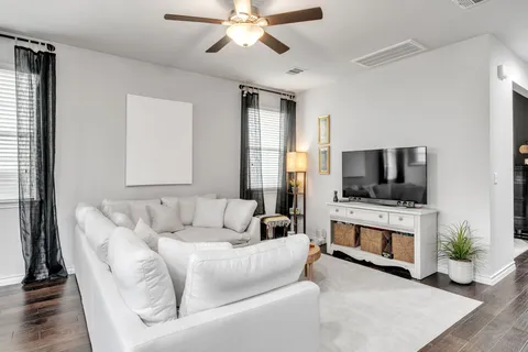 a living room with furniture a flat screen tv and a fireplace