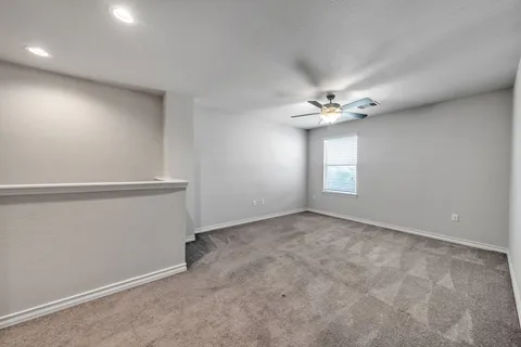 an empty room with a ceiling fan and window