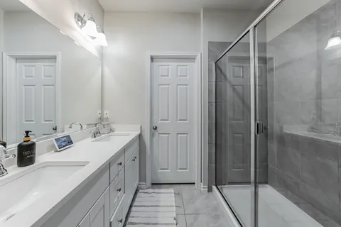 a bathroom with a double vanity sink and mirror