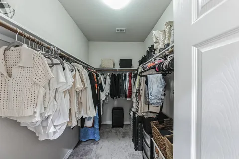 a view of walk in closet with clothes