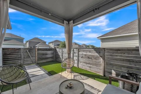 a view of a porch with furniture and a backyard