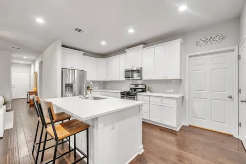 a kitchen with white cabinets and white appliances