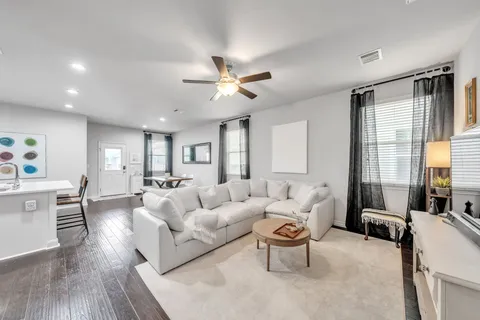 a living room with furniture a large window and a chandelier