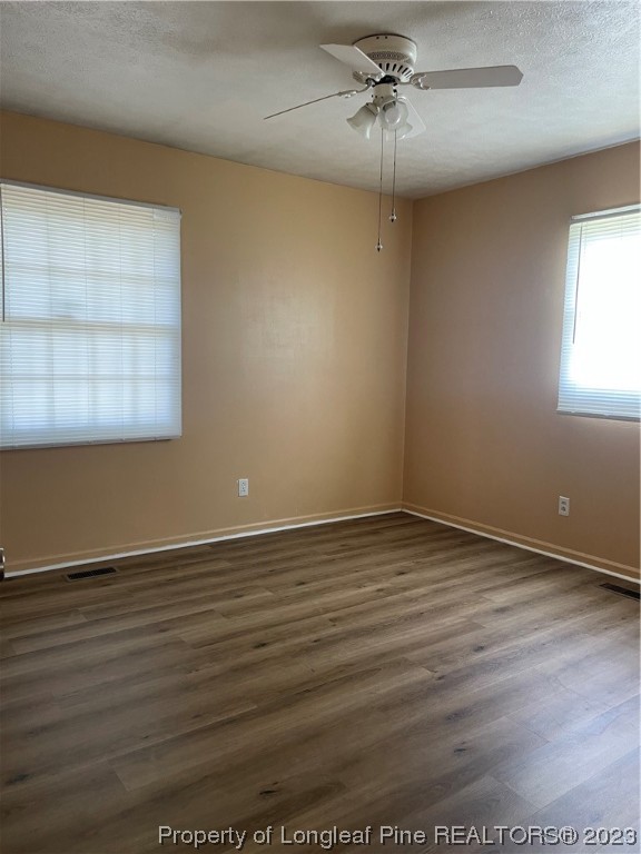 2676 Eldorado Road Fayetteville, NC 28306 - Photo 12 of 19 an empty room with wooden floor chandelier fan and windows
