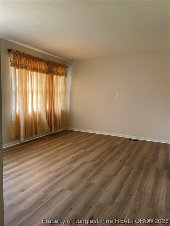 2676 Eldorado Road Fayetteville, NC 28306 - Photo 3 of 19 an empty room with wooden floor and windows