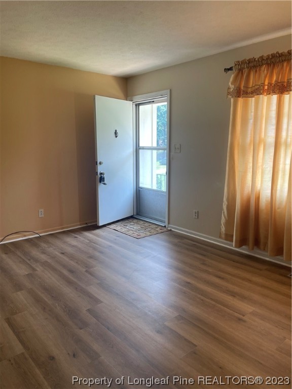 2676 Eldorado Road Fayetteville, NC 28306 - Photo 4 of 19 an empty room with wooden floor and windows