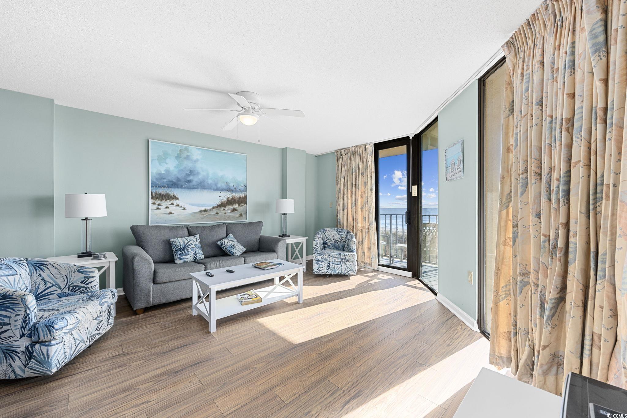 4701 South Ocean Boulevard, Unit 2B North Myrtle Beach, SC 29582 - Photo 11 of 31 Living room featuring wood finished floors, expansive windows, and a ceiling fan