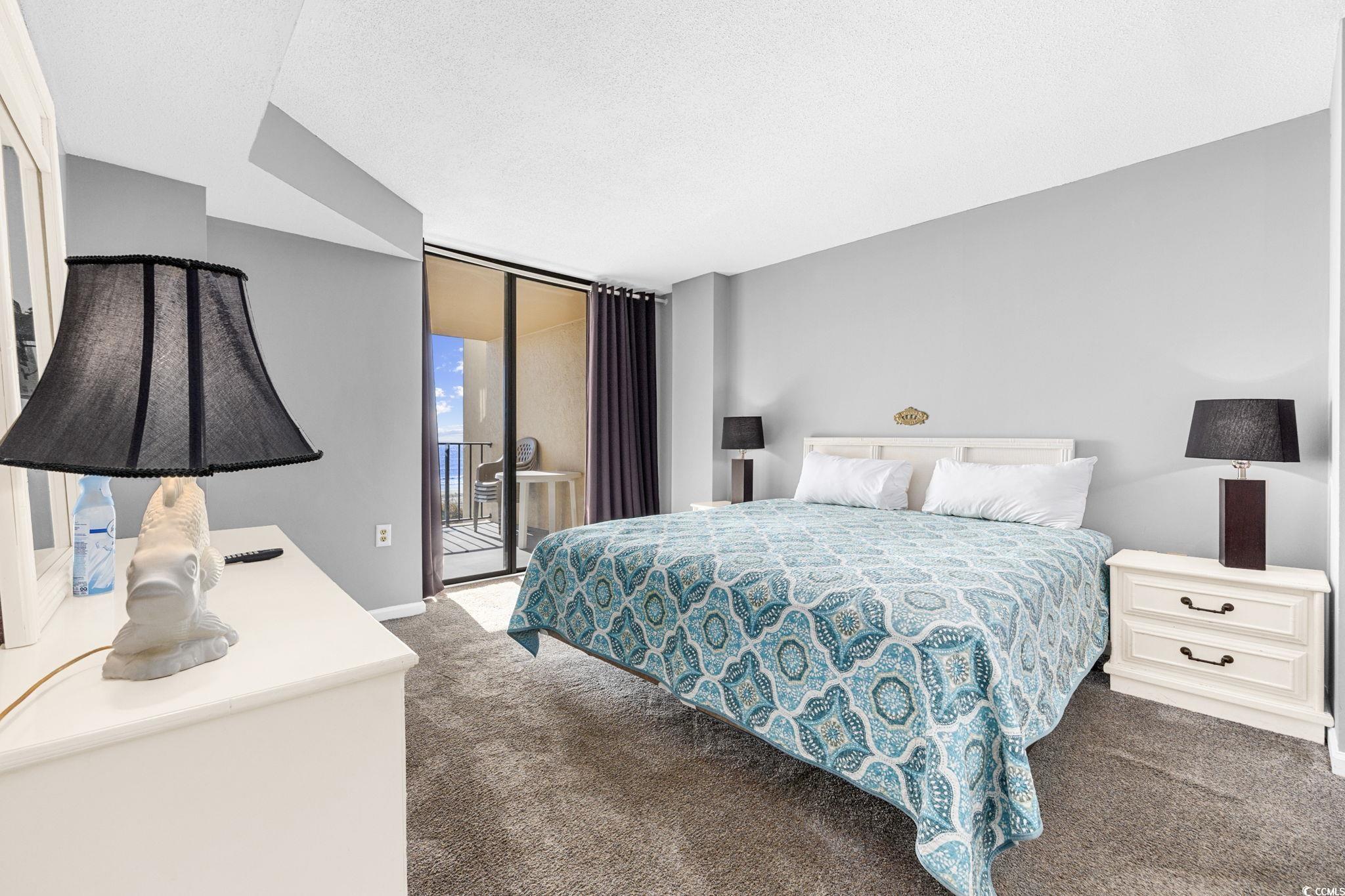 4701 South Ocean Boulevard, Unit 2B North Myrtle Beach, SC 29582 - Photo 17 of 31 Carpeted bedroom featuring access to outside, floor to ceiling windows, and a textured ceiling