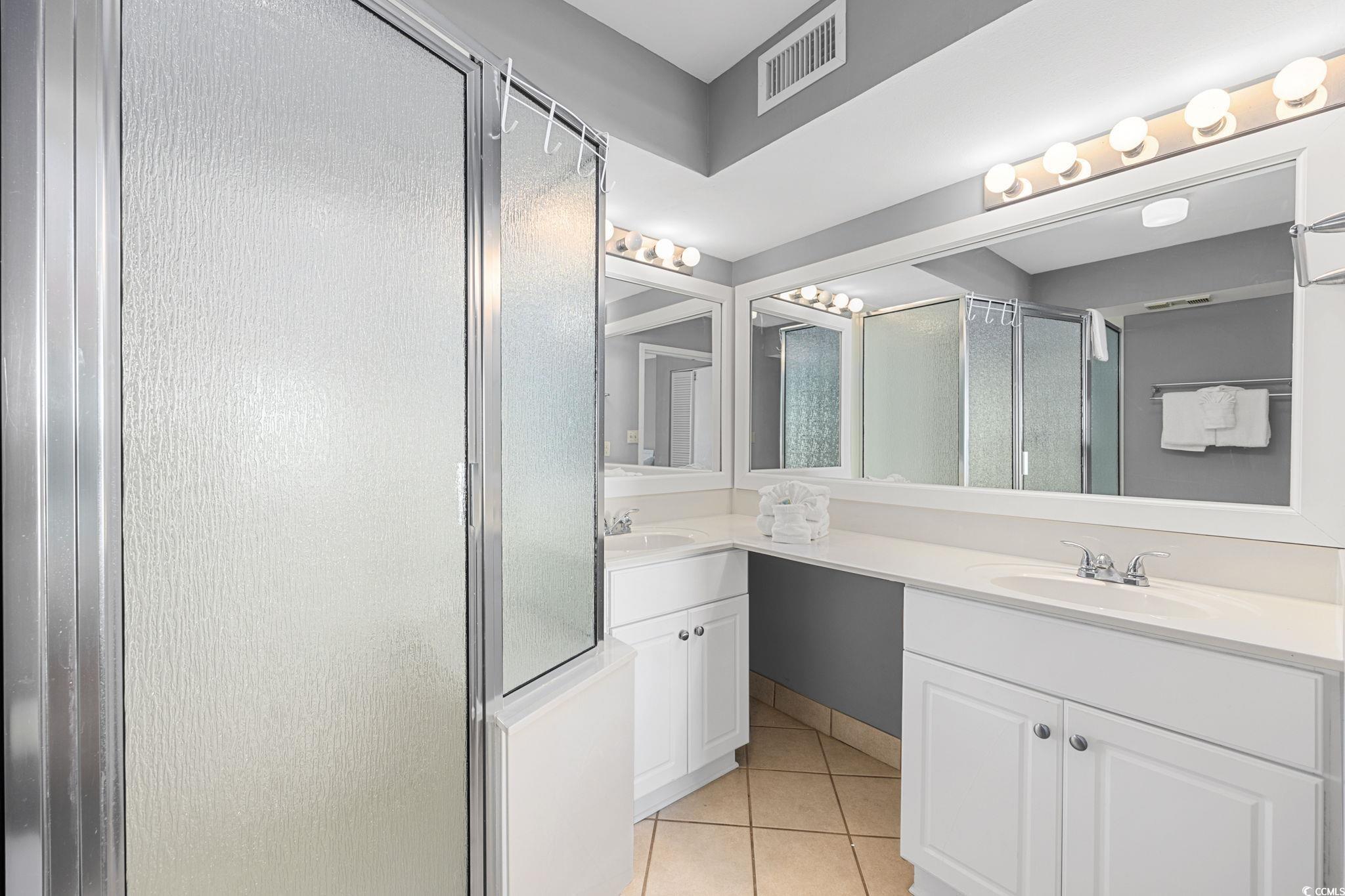 4701 South Ocean Boulevard, Unit 2B North Myrtle Beach, SC 29582 - Photo 21 of 31 Full bath featuring a shower stall, double vanity, and light tile patterned floors