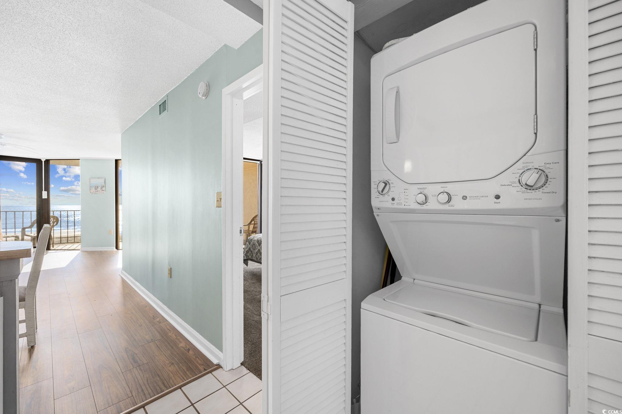 4701 South Ocean Boulevard, Unit 2B North Myrtle Beach, SC 29582 - Photo 24 of 31 Washroom with a textured ceiling, estacked washer and dryer, and wood finished floors