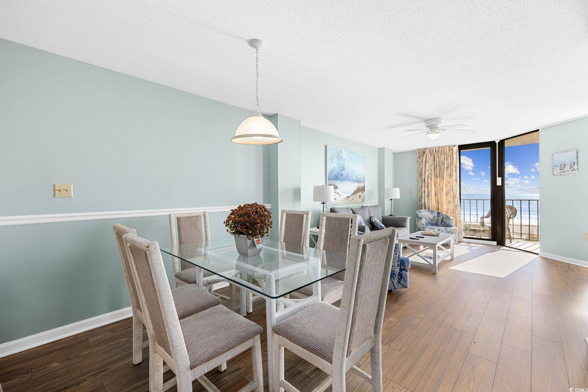 4701 South Ocean Boulevard, Unit 2B North Myrtle Beach, SC 29582 - Photo 9 of 31 Dining area featuring a textured ceiling, a wall of windows, dark wood-style flooring, and a ceiling fan