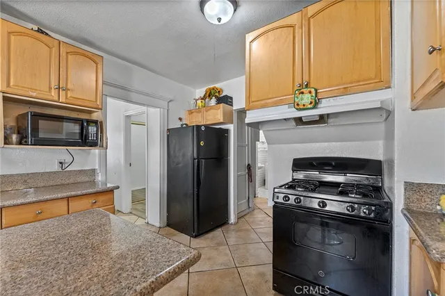 a kitchen with stainless steel appliances granite countertop a stove a refrigerator and a microwave