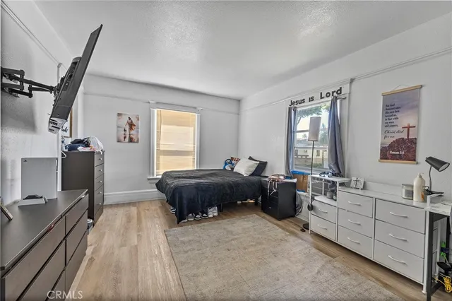 a spacious bedroom with a bed a table and large mirror