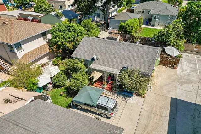 an aerial view of a house with a yard and a large tree