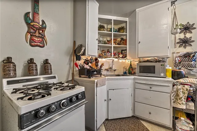 a white stove top oven sitting inside of a kitchen