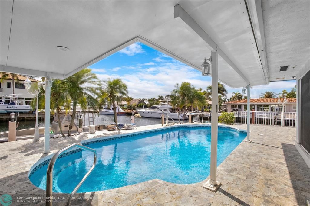 1311 Northeast 27th Way Pompano Beach, FL 33062 - Photo 11 of 58 a view of a swimming pool with a patio