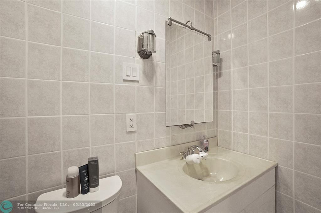 1311 Northeast 27th Way Pompano Beach, FL 33062 - Photo 19 of 58 a bathroom with a sink a bath tub and shower