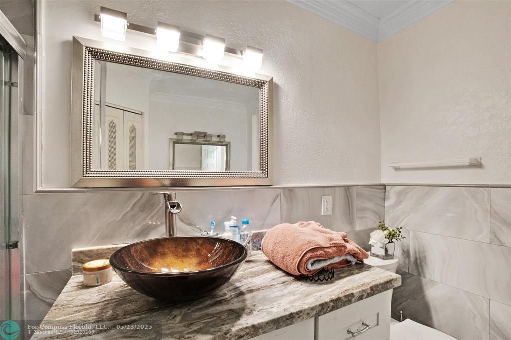 1311 Northeast 27th Way Pompano Beach, FL 33062 - Photo 21 of 58 a bathroom with a granite countertop sink and a mirror
