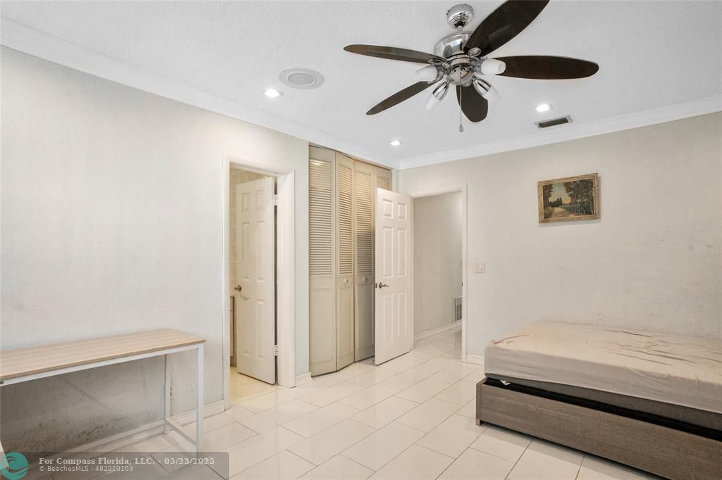 1311 Northeast 27th Way Pompano Beach, FL 33062 - Photo 24 of 58 a spacious bedroom with a bed and a ceiling fan