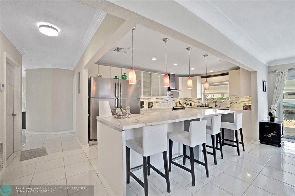 1311 Northeast 27th Way Pompano Beach, FL 33062 - Photo 40 of 58 a kitchen with kitchen island cabinets and chairs