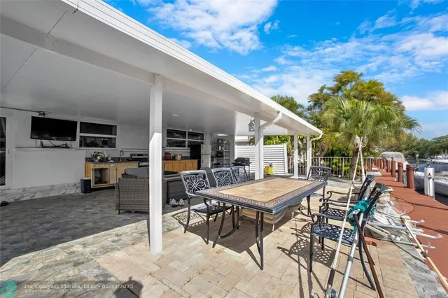 a patio with a table and chairs and potted plants