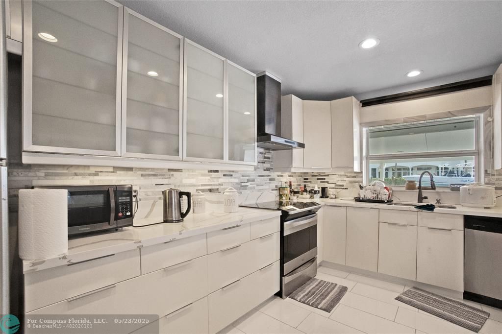 1311 Northeast 27th Way Pompano Beach, FL 33062 - Photo 42 of 58 a kitchen with appliances a sink and cabinets