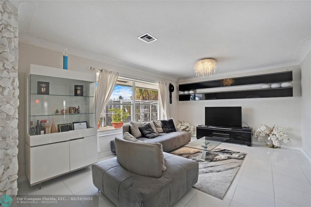1311 Northeast 27th Way Pompano Beach, FL 33062 - Photo 48 of 58 a living room with furniture and a flat screen tv