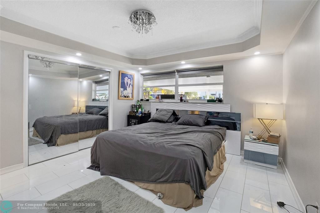 1311 Northeast 27th Way Pompano Beach, FL 33062 - Photo 54 of 58 a bedroom with a large bed and a large window