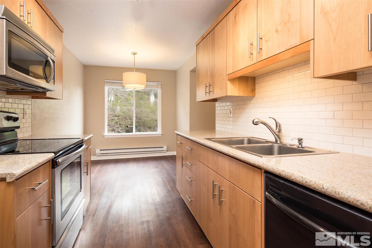 a kitchen with a sink a window and stainless steel appliances