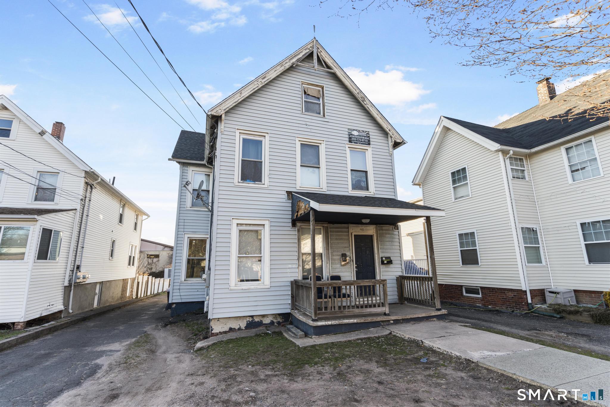 48 Fulton Street New Haven, CT 06513 - Photo 4 of 16 a view of a white house with large windows and wooden fence