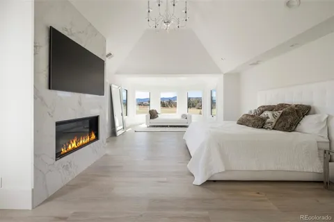 a spacious bedroom with a bed and a fireplace