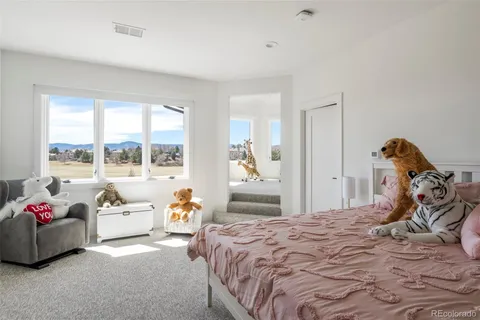 a bedroom with a bed and large windows