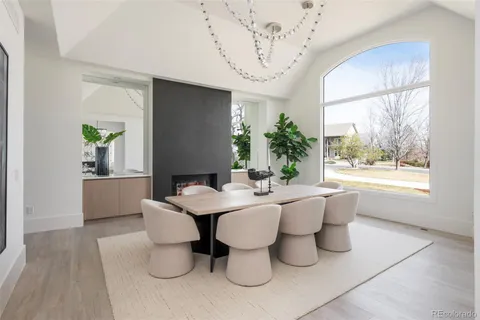 a dining room with furniture a large window and wooden floor