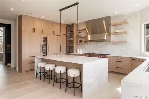 a kitchen with kitchen island granite countertop a wooden floor and white cabinets