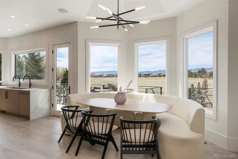 a dining room with furniture a chandelier and wooden floor