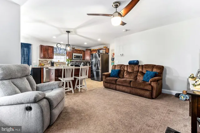a living room with furniture and kitchen view
