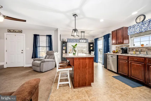 a kitchen with stainless steel appliances granite countertop a stove top oven a sink dishwasher and a wooden cabinets