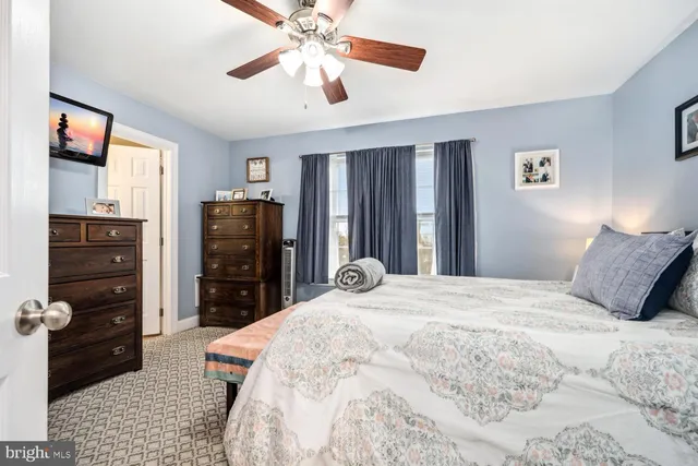 a bedroom with a bed and a flat tv screen on dresser