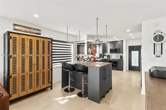 a kitchen with kitchen island granite countertop a sink and a stove