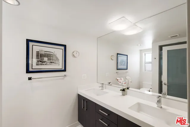 a bathroom with a double vanity sink and a mirror