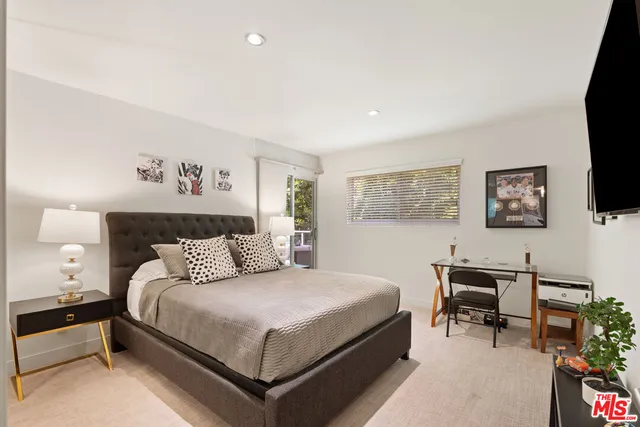 a bedroom with a bed a bookshelf and a desk